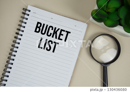 Bucket List text on paper notebook with magnifying glass on beige leather background 130436080