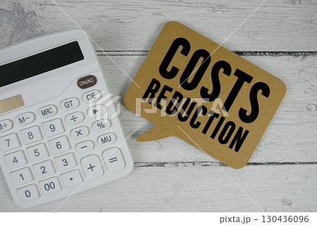 Costs Reduction text with calculator on wooden background 130436096