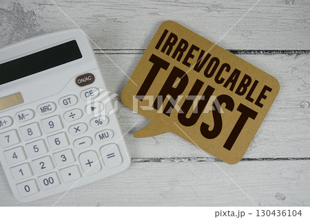 Irrevocable Trust text with calculator on wooden background 130436104