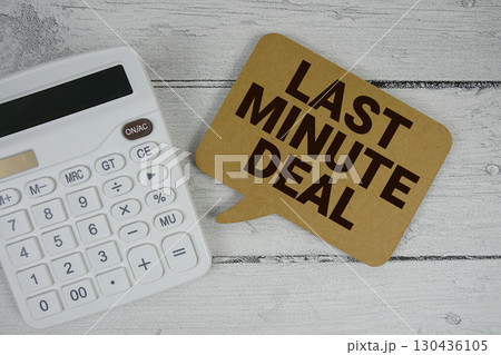 Last Minute Deal text with calculator on wooden background 130436105