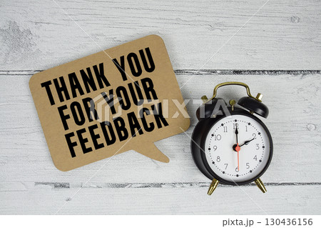 Thank you text with alarm clock on wooden background Thank you text with alarm clock on wooden background 130436156