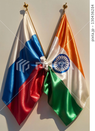tied indian and russian flags hanging on white wall, close up tied indian and russian flags hanging on white wall, close up 130436284