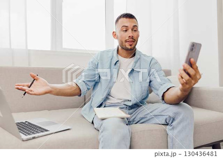 Engaged man communicating on phone, expressing emotions. Balancing work-life while navigating modern challenges of technology and mental health. Engaged man communicating on phone, expressing emotions. Balancing work-life while navigating modern challenges of technology and mental health. 130436481