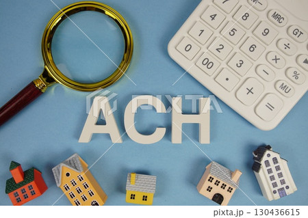 ACH abbreviation of Automated Clearing House alphabet letters with house model, magnifying glass and calculator on blue background 130436615