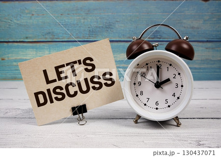 Let's Discuss text written on paper card with alarm clock on wooden background 130437071
