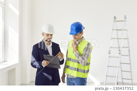 Businessman And Builder Planning Home Or Office Renovation Businessman And Builder Planning Home Or Office Renovation 130437352