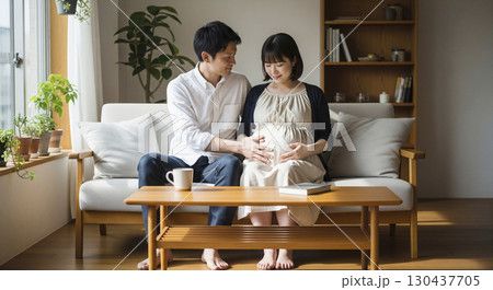 大きくなった妻のお腹を撫でる夫 大きくなった妻のお腹を撫でる夫 130437705