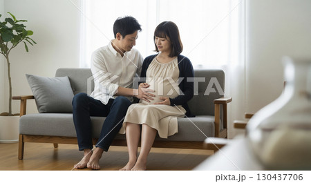 大きくなった妻のお腹を撫でる夫 130437706