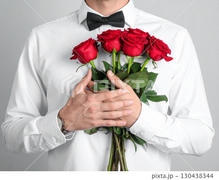 胸元に赤いバラを添える男性 130438344