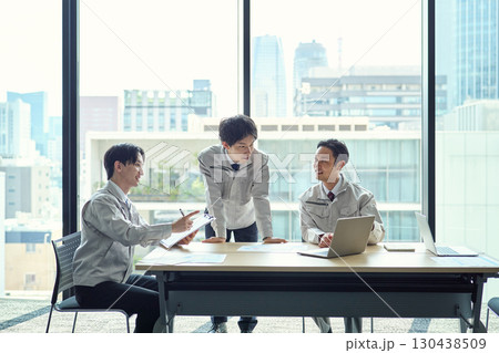 打ち合わせをする作業服姿の男性 130438509