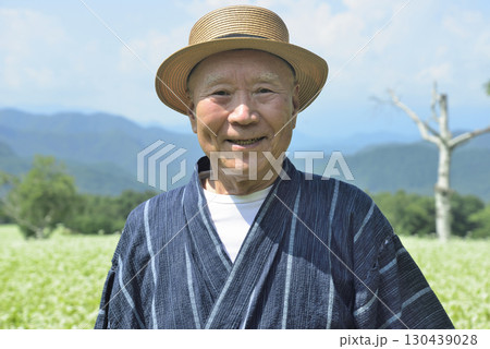 ソバ畑を散策している老人 130439028