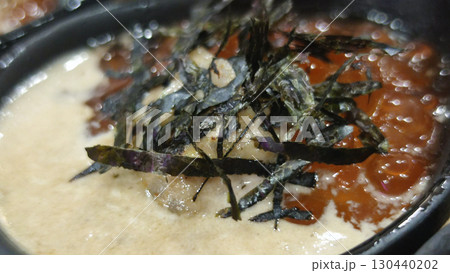 Creamy soup with seaweed garnish and orange fish roe in black bowl, showcasing rich texture and fresh seafood ingredients for flavorful meal experience Creamy soup with seaweed garnish and orange fish roe in black bowl, showcasing rich texture and fresh seafood ingredients for flavorful meal experience 130440202