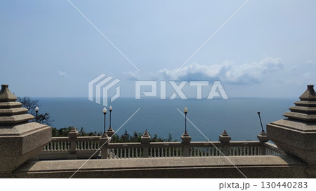 Serene seascape view from an ornate architectural balcony overlooking calm blue ocean. peaceful and tranquil vista with vast sky and horizon from high viewpoint 130440283