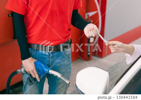 Gas station staff worker receiving cash money for fuel bill payment, Petroleum business Gas station staff worker receiving cash money for fuel bill payment, Petroleum business 130441584