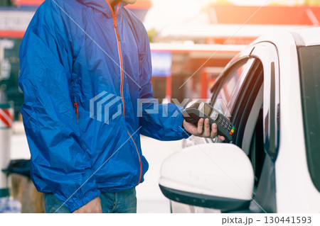 Closeup gas station staff worker with credit card swiping machine for payment, Petroleum business 130441593