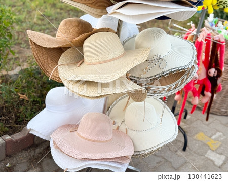 Bright summer hats on store rack. Fashion, tourism, and lifestyle accessories for sunny days. 130441623