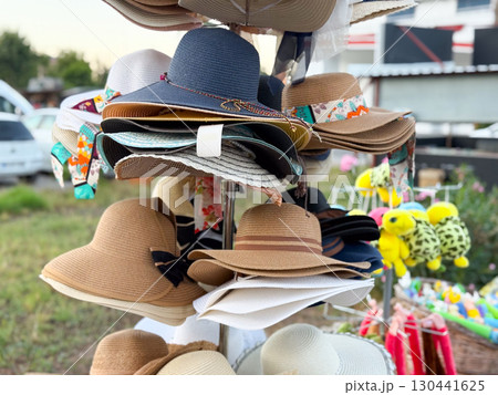 Bright summer hats on store rack. Fashion, tourism, and lifestyle accessories for sunny days. Bright summer hats on store rack. Fashion, tourism, and lifestyle accessories for sunny days. 130441625