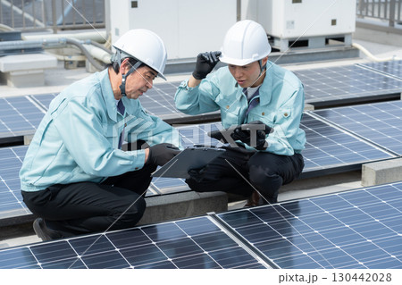 ソーラーパネルをメンテナンスする作業員 130442028