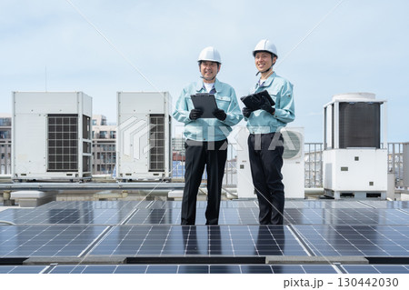 ソーラーパネルをメンテナンスする作業員 130442030