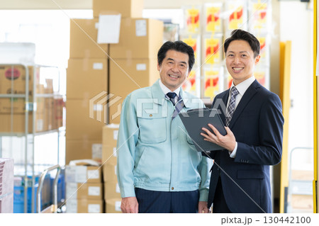 倉庫で商談をする経営者とビジネスマン 130442100