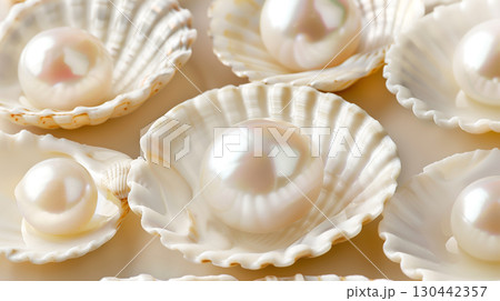 Delicate pearls nestled in creamy oyster shells on a fabric backdrop Delicate pearls nestled in creamy oyster shells on a fabric backdrop 130442357