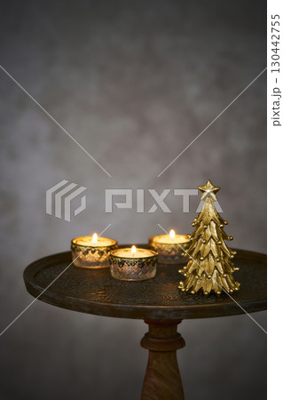アンティークなサイドテーブルに置かれたクリスマスツリーとキャンドル 130442755