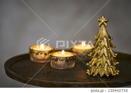 アンティークなサイドテーブルに置かれたクリスマスツリーとキャンドル 130442758