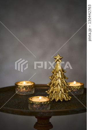 アンティークなサイドテーブルに置かれたクリスマスツリーとキャンドル 130442763