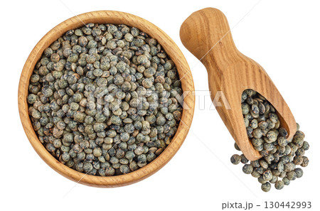 raw french green lentils in wooden bowl and scoop isolated on white background. Top view. Flat lay raw french green lentils in wooden bowl and scoop isolated on white background. Top view. Flat lay 130442993