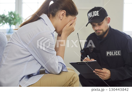 Crying woman gives statement to police officer at home 130443842