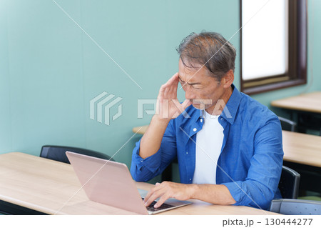 ノートパソコンを使い考えるシニア男性 ノートパソコンを使い考えるシニア男性 130444277