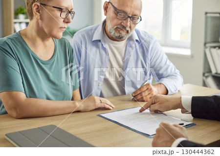 Senior elderly couple sitting with financial advisor in office for consultation Senior elderly couple sitting with financial advisor in office for consultation 130444362