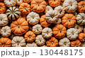 Colorful autumn pumpkins in white and orange shades surrounded by dry maple leaves 130448175