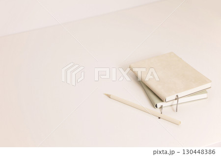 Beige and green notebooks and color pencil on minimal desk 130448386