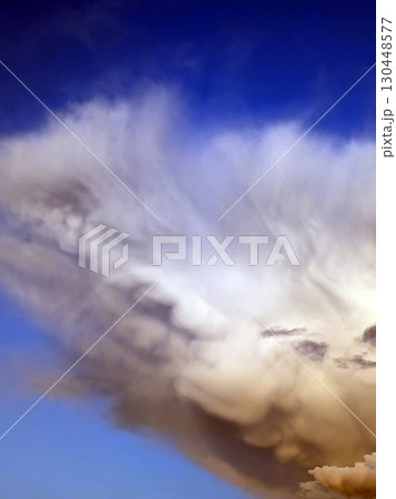 Thick stormy thunderstorm clouds in a blue sky 130448577
