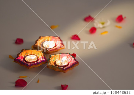 Diwali candle arrangement with vibrant marigold flowers and petals 130448632