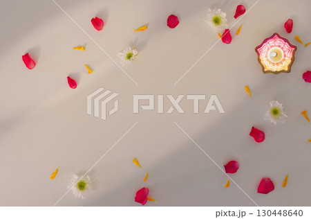 Single Diwali candle surrounded by flower petals for festive decor Single Diwali candle surrounded by flower petals for festive decor 130448640