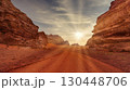 Sunset casts golden light over red rock formations in desert landscape. Wadi Rum, Jordan. 130448706