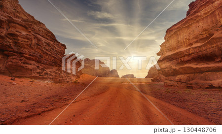 Sunset casts golden light over red rock formations in desert landscape. Wadi Rum, Jordan. Sunset casts golden light over red rock formations in desert landscape. Wadi Rum, Jordan. 130448706