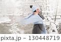 Winter joy as woman embraces the snow in a serene outdoor setting by the river 130448719