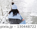 Woman enjoying winter snow by the river while promoting mental health and wellness 130448722