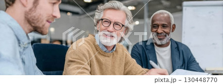 Older professionals engage in lively discussions with younger colleagues at a modern workspace Older professionals engage in lively discussions with younger colleagues at a modern workspace 130448770