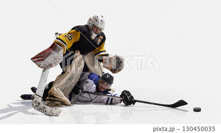 Hockey goalkeeper in yellow jersey standing over fallen rival with dominance Hockey goalkeeper in yellow jersey standing over fallen rival with dominance 130450035