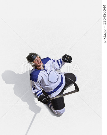Top angle hockey forward in blue jersey shouting with joy after scoring 130450044