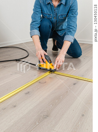 DIY home project measuring with laser tool on wooden floor, creativity DIY home project measuring with laser tool on wooden floor, creativity 130450118