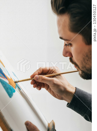 Focused artist painting vibrant artwork in studio, creative expression 130450127