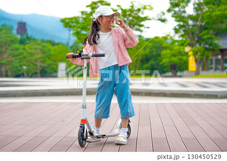 Asian girl is going to ride a scooter. Copy space Asian girl is going to ride a scooter. Copy space 130450529