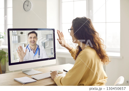 Woman says hello to online doctor when they start medical consultation via video call Woman says hello to online doctor when they start medical consultation via video call 130450657