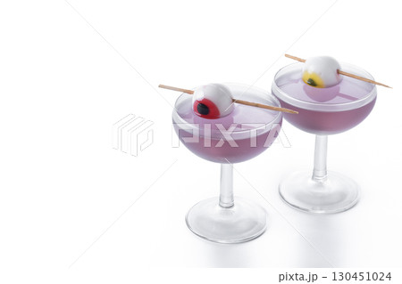 Purple Halloween cocktail garnished with candy eye 130451024