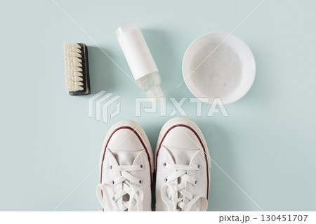 Concept of cleaning and washing white shoes by special foam and brush on blue background. Washing and cleaning concept. View from above. 130451707